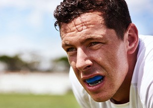 Closeup of man on field wearing blue mouthguard