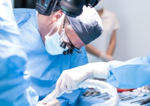 A male oral surgeon performing a dental implant surgery