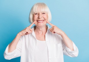 An older woman who’s received her dental implant’s restoration