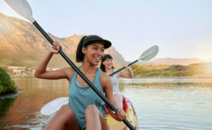 Two women smiling while kayaking down a mountain river